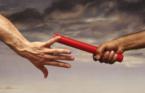 Close-up on the Hand of a Male Athlete Passing a Relay Baton to Another Athlete, With a Dramatic Sky in the Background